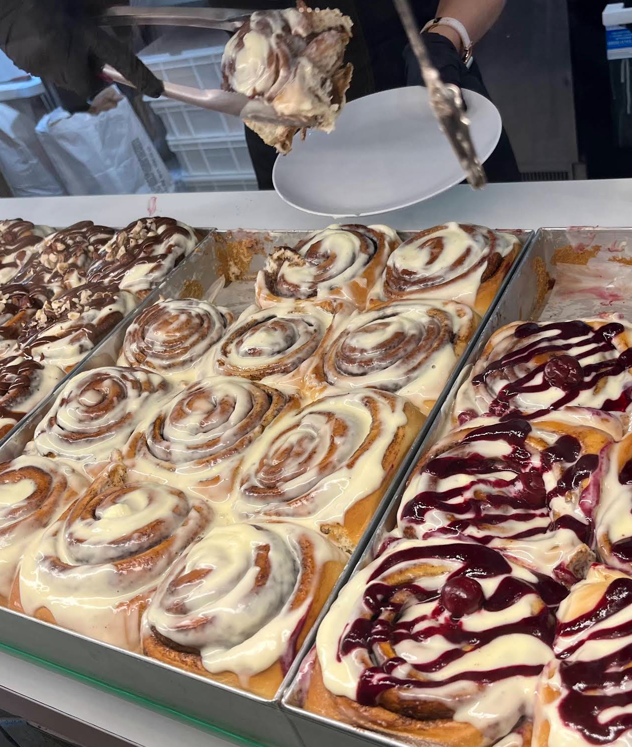 Trays of freshly baked cinnamon rolls in the display case